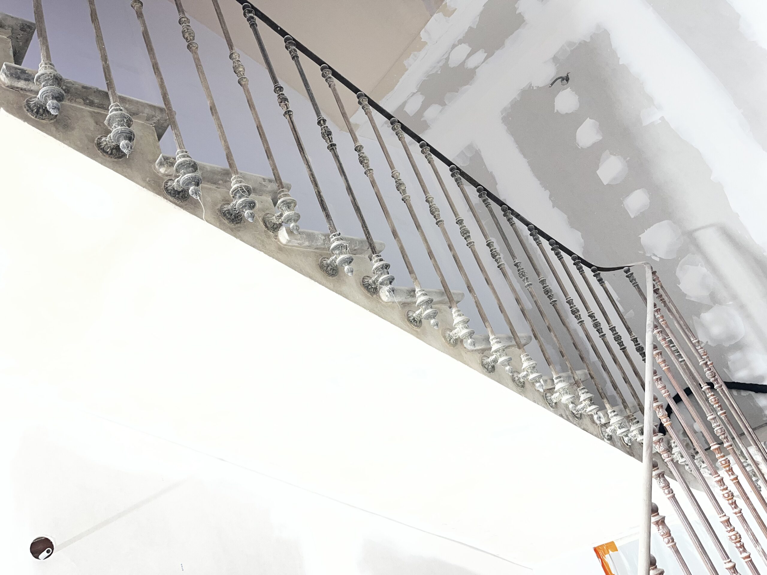 DÉCAPAGE D'UNE RAMPE D'ESCALIER QUI PERMET D'ENLEVER LA ROUILLE ET L'ANCIENNE PEINTURE