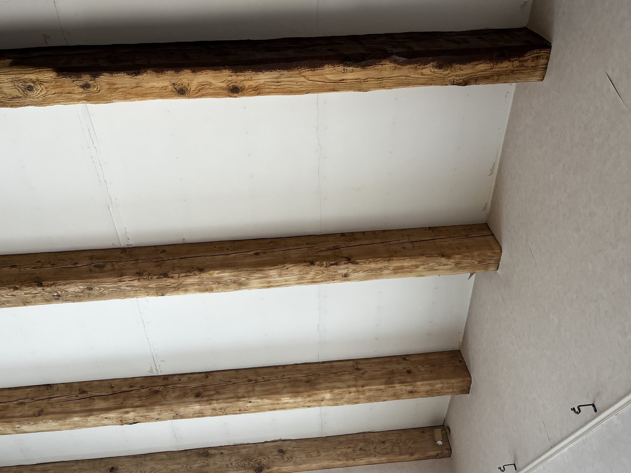 TRAVAUX D'AÉROGOMMAGE EN COURS DE DÉCAPAGE DE POUTRE BOIS